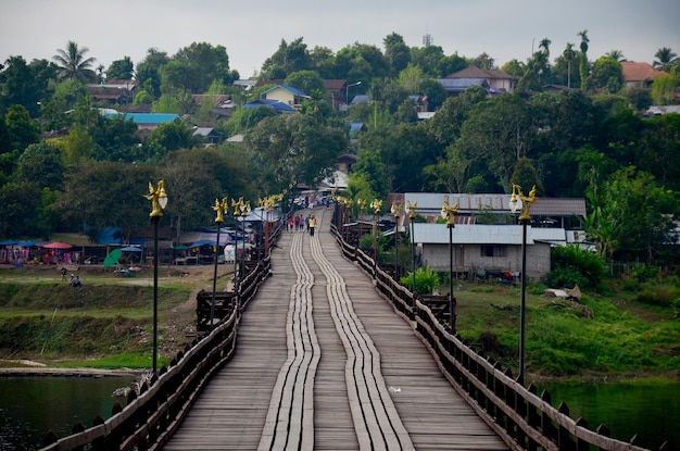 Mensen reizen en lopen op de houten brug Saphan Mon in de ochtendtijd in Sangkhlaburi op 4 december 2015 in Kanchanaburi, Thailand