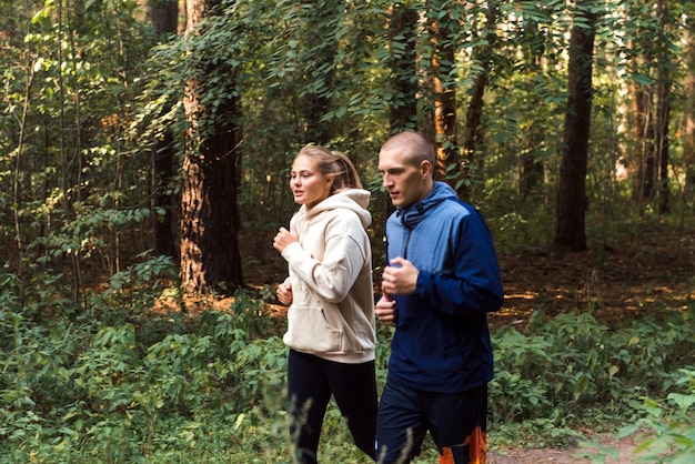 mensen rennen in het bos jonge man en vrouw joggen in het park