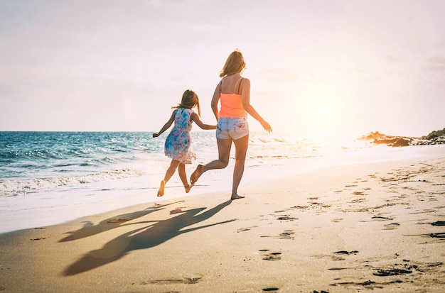 Mensen rennen op het strand tegen de hemel tijdens de zonsondergang