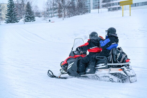 Mensen rijden op een sneeuwscooter in het bevroren sneeuwmeer in de winter Rovaniemi, Lapland, Finland