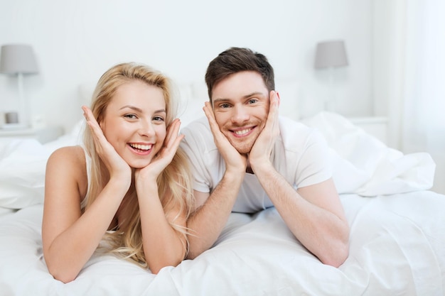 mensen, rust, liefde, relaties en geluk concept - gelukkige paar thuis in bed liggen