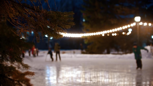 Mensen schaatsen op de versierde openbare ijsbaan terwijl kerstmis buiten is