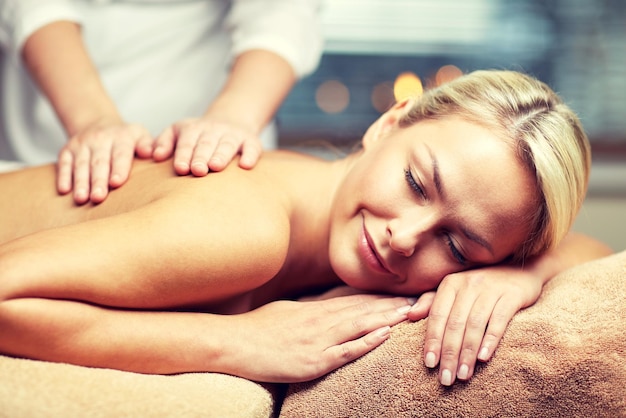 mensen, schoonheid, spa, gezonde levensstijl en ontspanningsconcept - close-up van mooie jonge vrouw die met gesloten ogen ligt en handmassage heeft in spa