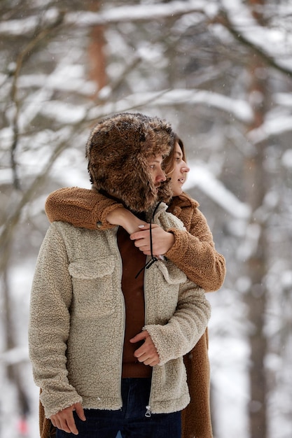 Mensen seizoen liefde en vrije tijd concept gelukkig paar knuffelen en lachen buiten in de winter Paar omhelzen en plezier hebben in besneeuwde winter park