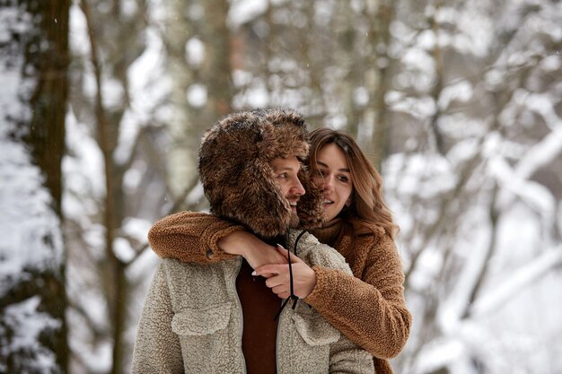 Mensen seizoen liefde en vrije tijd concept gelukkig paar knuffelen en lachen buiten in de winter Paar omhelzen en plezier hebben in besneeuwde winter park