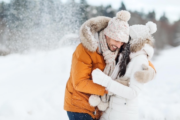 mensen, seizoen, liefde en vrije tijd concept - gelukkig paar knuffelen en lachen buiten in de winter