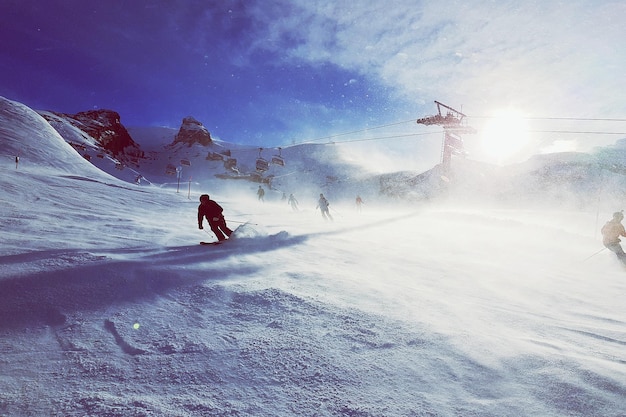 Foto mensen skiën op een besneeuwde berg tegen de lucht