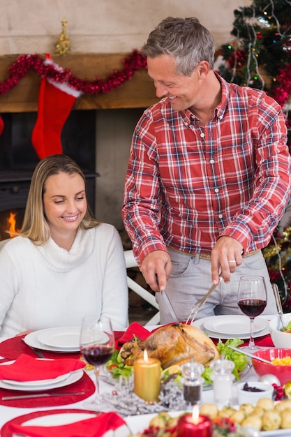 Mensen snijdende kip tijdens Kerstmisdiner