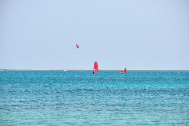 Mensen sporters windsurfen en kitesurfen in blauw oceaanwater Zomer extreem exotisch sportconcept