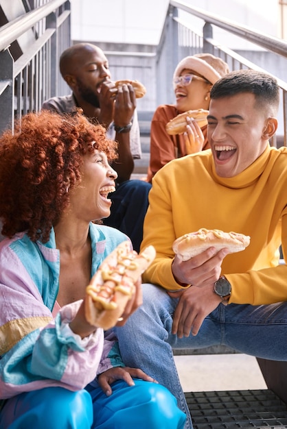 Foto mensen stad en vrienden eten hotdog buiten voor reizen grappig lachen en plezier op trappen diversiteit geluk en gen z groep mannen en vrouwen met eten op date avontuur en vrijheid in stedelijke stad