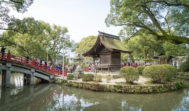 Mensen steken de beroemde rode brug van het heiligdom van Dazaifu over.