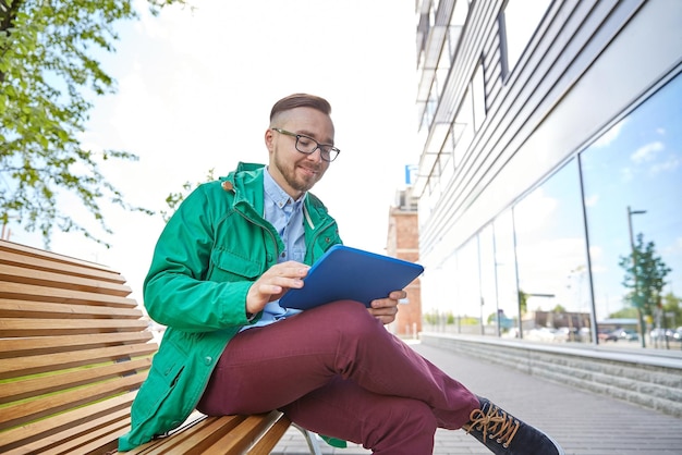mensen, stijl, technologie en levensstijl - gelukkige jonge hipster man met tablet pc-computer en fixie fiets zittend op een bankje in de stad