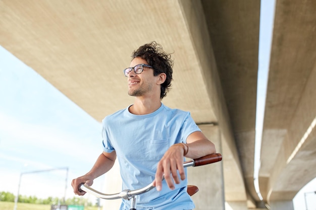 mensen, stijl, vrije tijd en levensstijl - jonge hipster-man met vaste versnellingsfiets op straat in de stad