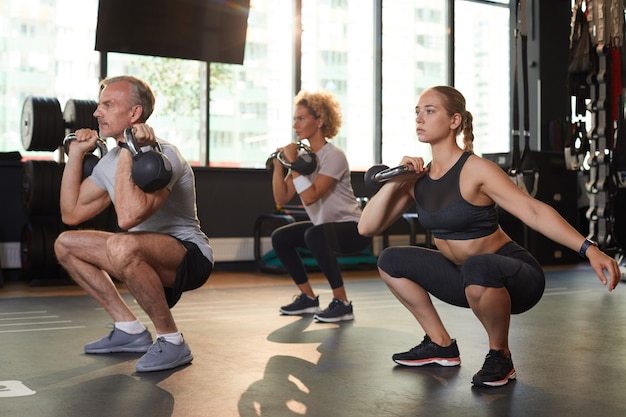 Mensen trainen met halters tijdens sportles in gezondheidsclub