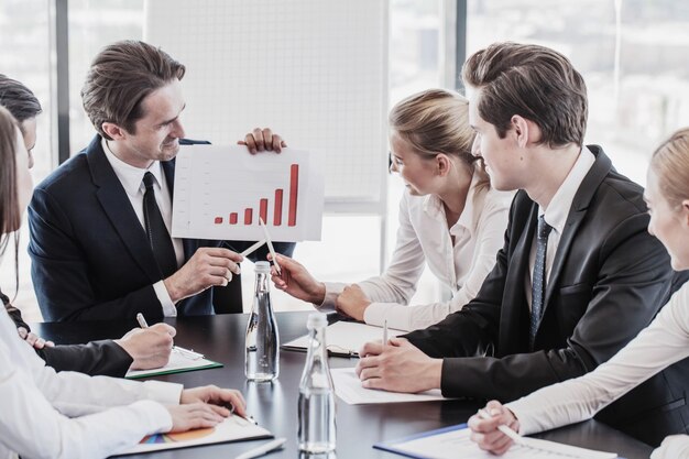 Mensen uit het bedrijfsleven bespreken de grafieken en grafieken die de resultaten van hun succesvolle teamwerk laten zien