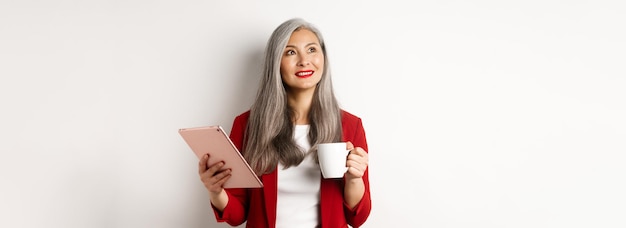 Mensen uit het bedrijfsleven concept aziatische zakenvrouw koffie drinken en digitale tablet glimlachend houden