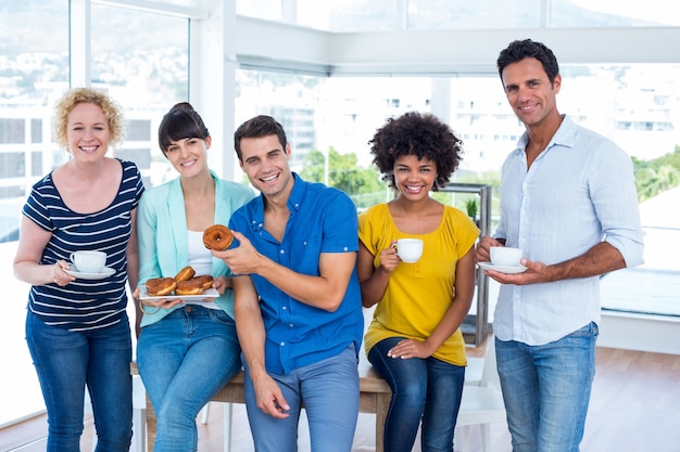 Mensen uit het bedrijfsleven die donuts eten en drinken