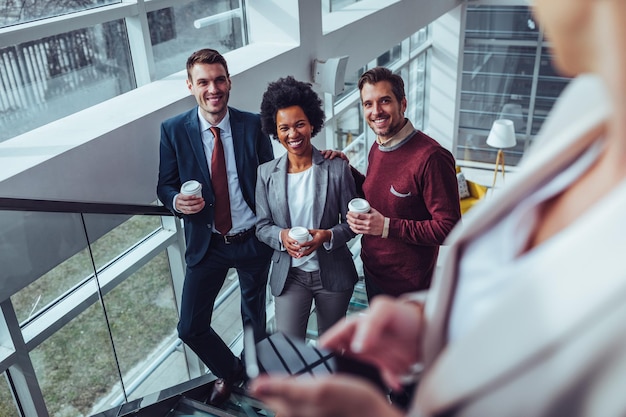 Mensen uit het bedrijfsleven die technologie gebruiken en koffie drinken tijdens hun kantoorpauze