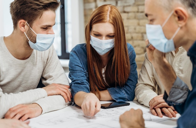 Mensen uit het bedrijfsleven dragen medische maskers op kantoor