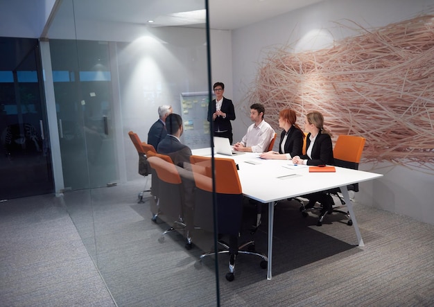 mensen uit het bedrijfsleven groeperen met jonge volwassenen en senioren tijdens een ontmoeting in een modern, licht kantoorinterieur.