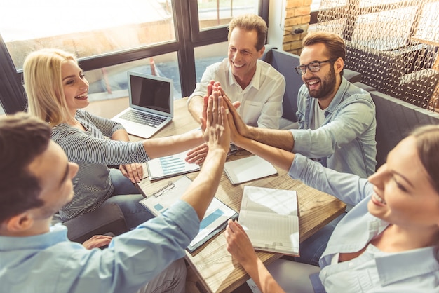 Mensen uit het bedrijfsleven in slimme vrijetijdskleding geven high five