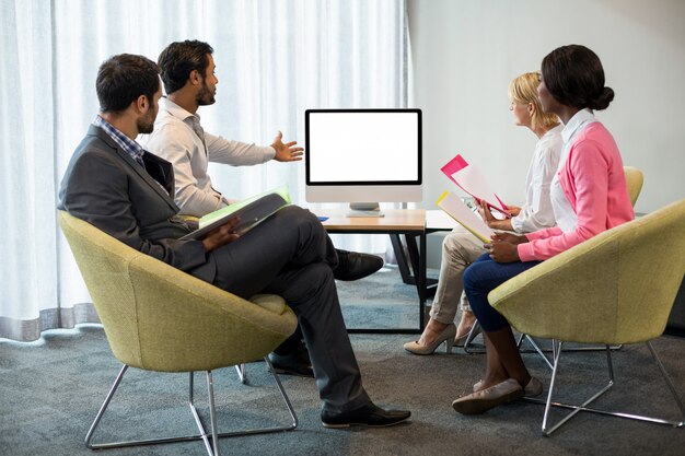 Mensen uit het bedrijfsleven kijken naar een scherm tijdens een videoconferentie