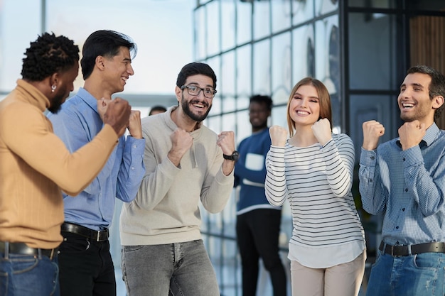 Mensen uit het bedrijfsleven vieren en balden hun vuisten in de lucht als een winnend team