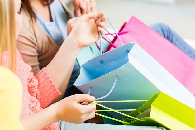 mensen, verkoop, consumentisme en levensstijlconcept - close-up van tienermeisjes of jonge vrouwen met boodschappentassen