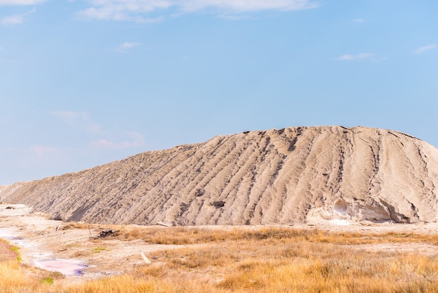 Mensen verzamelen zout van het roze zoute siwash-meer, gekleurd door microalgen, beroemd om zijn antioxiderende eigenschappen, verrijkend water met bètacaroteen bij zonsondergang