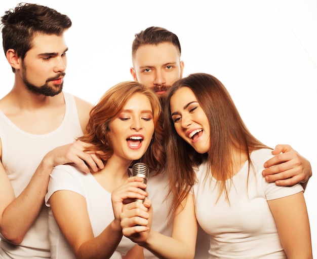 Mensen, vriendschap en vrije tijd concept: groep jonge gelukkige vrienden die plezier hebben in karaoke, hipster-stijl. Geïsoleerd op wit.