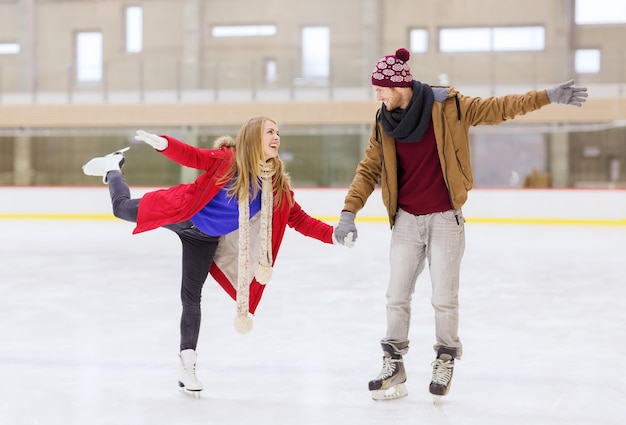 mensen, vriendschap, sport en vrije tijd concept - gelukkig paar hand in hand op ijsbaan