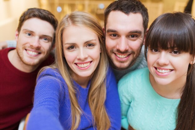 mensen, vrije tijd, vriendschap en technologieconcept - groep glimlachende vrienden die selfie nemen