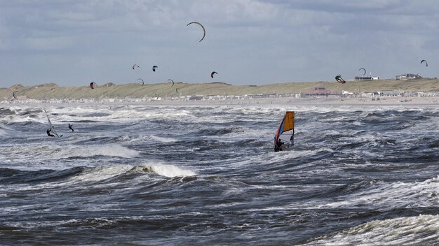 Foto mensen windsurfen tegen een bewolkte hemel