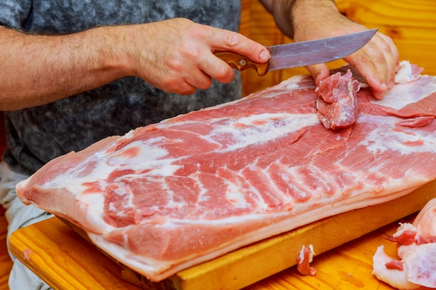 Mensenbesnoeiingen van vers stuk van vlees op een houten scherpe raad in huiskeuken