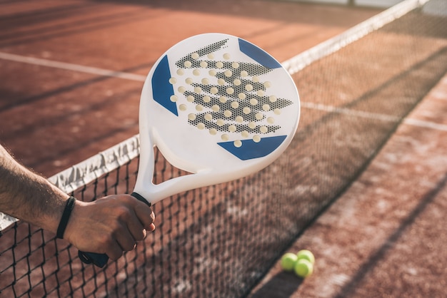 Mensenhand die een padelracket grijpen