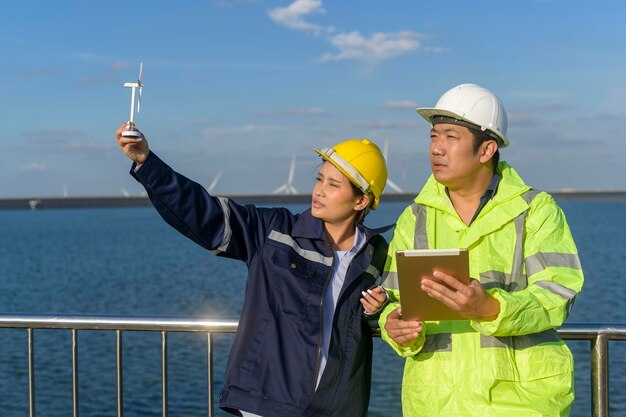 Menseningenieur draagt een beschermende helm op het hoofd, met behulp van tablet Analytics-engineeringgegevens.