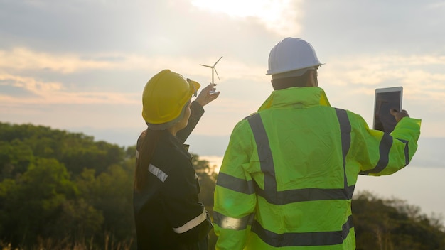 Menseningenieur draagt een beschermende helm op het hoofd, met behulp van tablet Analytics-engineeringgegevens.