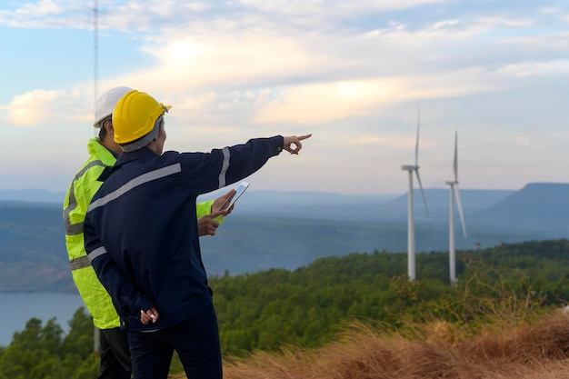 Menseningenieur draagt een beschermende helm op het hoofd, met behulp van tablet Analytics-engineeringgegevens.