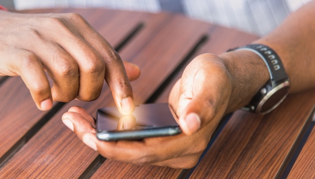 Mensenpersoon die een moderne slimme telefoon houden en een vinger aanraken aan het lege scherm