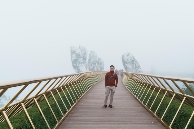 Mensenreiziger die de Gouden brug bezoekt op de top van het Ba Na Hills-oriëntatiepunt en het populaire reisconcept voor Vietnam en Zuidoost-Azië