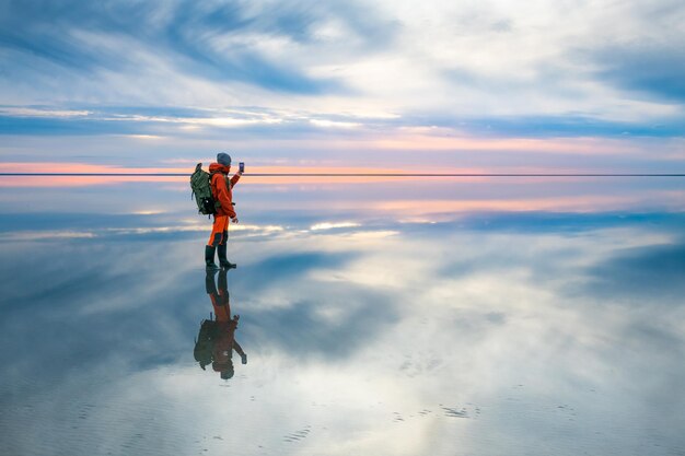 Mensenreiziger die foto van het mooie meer nemen bij zonsondergang