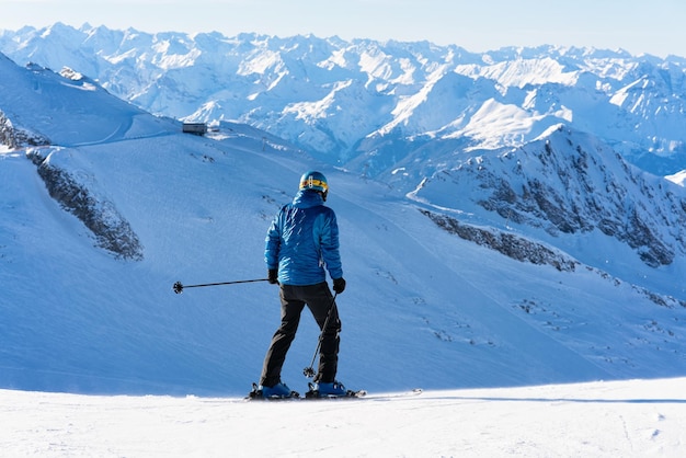 Mensenskiër bij Hintertux-gletsjerskigebied in Zillertal in Tirol. Oostenrijk in de winter in Alpen. Persoon bij Alpine bergen met sneeuw. Bergaf plezier. Blauwe lucht en witte hellingen. Hintertuxer Gletscher.