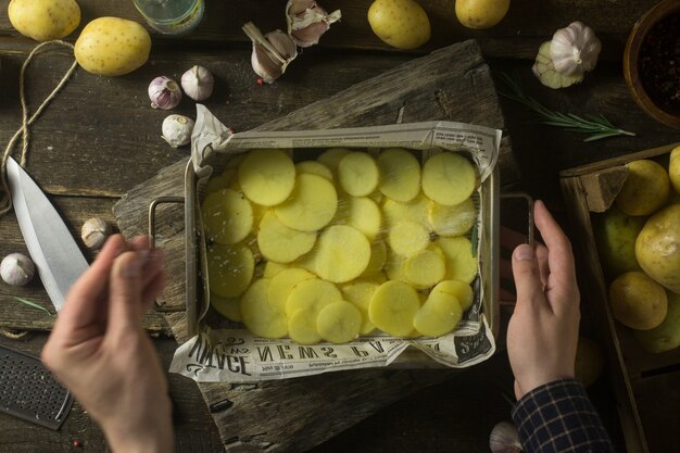 Mensenzout gesneden aardappels voor het koken op rustieke houten lijst