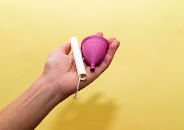 Menstrual cup alternative to uncomfortable tampons on yellow background Feminine hygiene products