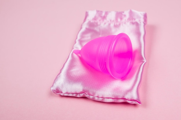 Menstrual cup and bag on isolated pink background The concept of women's periods