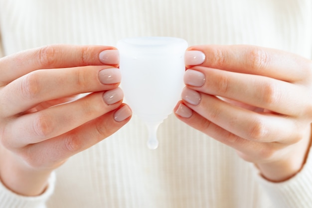 Menstrual cup in hands of a woman close up photo