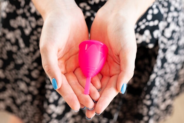 Menstrual cup in hands of a woman close up