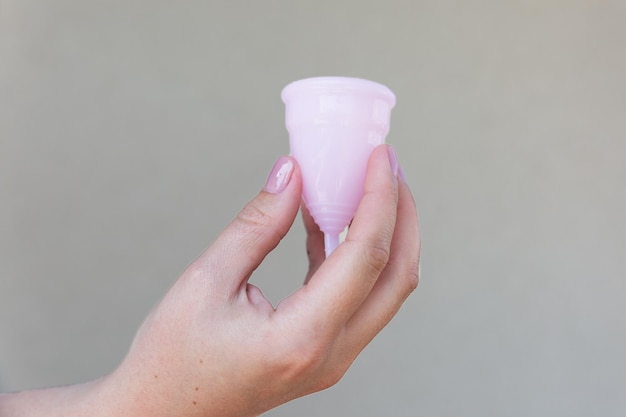 The menstrual cup is held in one hand Selective focus