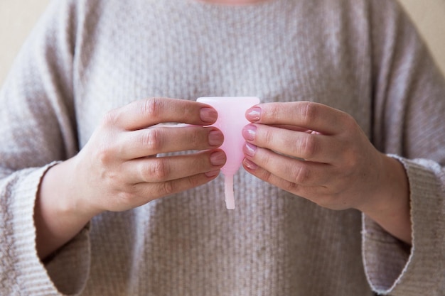 The menstrual cup is holding by woman hands Selective focus