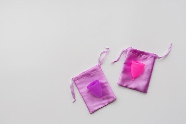 Menstrual cup on white paper background. Alternative feminine hygiene product during the period. 